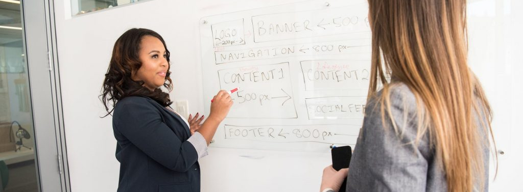 A mentor teaching in front of a whiteboard